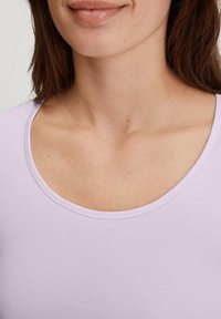 Lila aansluitend t-shirt met een brede ronde hals, gemaakt van zachte stof. Gestikte randen en een gladde textuur, met minimale zichtbare details.