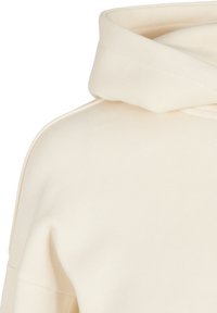 Sweat à capuche blanc cassé montrant la capuche pliée et une partie de l'épaule avec une texture de tissu lisse.