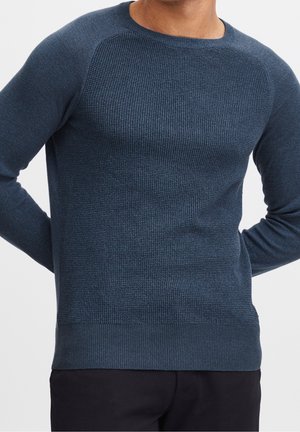 Navyblauer strukturierter Pullover mit Rundhalsausschnitt, geripptem Saum und Raglanärmeln, aus einem weichen Strickstoff mit einer figurbetonten Silhouette.