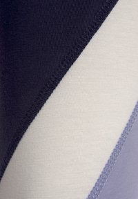 Textile material features a blend of dark navy, light cream, and lavender colors in a diagonal pattern, with textured seams and smooth finishes.