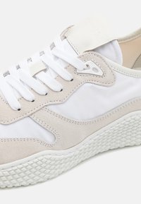 Vita och beige sneakers med överdel i mocka och nylon, med en strukturerad vit gummisole och snörning. Calvin Klein-logotypen är närvarande.