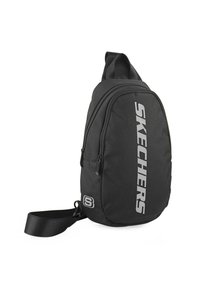 Mochila de tiro negra con tejido texturizado, que cuenta con dos compartimentos con cremallera y un gran logo "SKECHERS" en plata en la parte frontal.