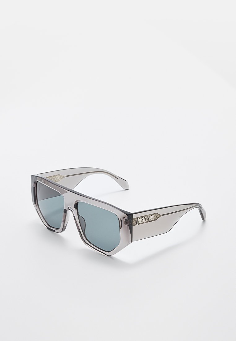 Lunettes de soleil grises avec monture carrée, verres teintés et accents texturés subtils sur les branches, avec un détail de logo sur un côté.
