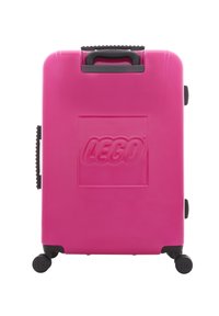Pink hard-shell suitcase with embossed "LEGO" logo, black handle, and four black wheels. Smooth texture and rectangular shape.