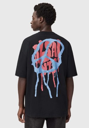 Čierne bavlnené tričko s veľkým červeným a modrým grafickým dizajnom na chrbte, znázorňujúcim prečiarknutý symbol s kvapkami farby.