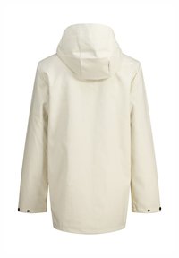 Chaqueta beige impermeable con capucha, mangas largas y cierres a presión en los puños. Textura suave, diseño minimalista sin logotipos visibles.