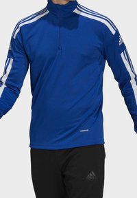 Haut de sport bleu à manches longues avec un col à fermeture éclair sur la moitié, des accents de bandes blanches sur les épaules et un label "AEROREADY" à l'ourlet.