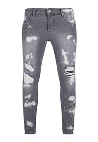 Jeans ajustados en un lavado gris deslavado con rotos desgastados. Incluyen un diseño de cinco bolsillos y cierre de botón metálico. Tejido texturizado.