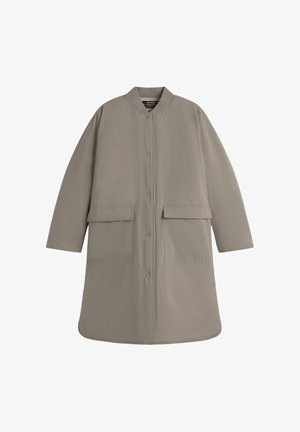 Abrigo largo de color beige claro, hecho de una tela suave, con un escote redondo, botones a presión en la parte delantera y dos grandes bolsillos frontales.