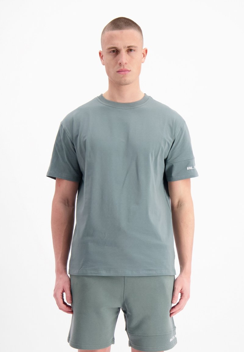 Lichtgroen katoenen t-shirt met een ronde hals en korte mouwen, voorzien van een klein logo in het wit op de linkermouw. Gladde textuur.