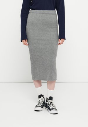Grå bomulds-midi-nederdel med en tætsiddende silhuet, der har en glat tekstur og en bred talje, kombineret med sorte høj-top sneakers og hvide sokker.