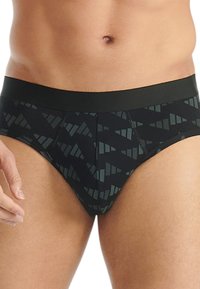 Mustat alushousut, joissa on tummanvihreä geometrinen kuvio, tukevalla elastisella vyötärönauhella ja klassisella alushousuleikkauksella. Pehmeä kangas.