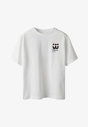 Balta kokvilnas T-kreklā ar īsām piedurknēm, apaļu kakla izgriezumu un melnu grafiku "CREATIVE CLUB" kreisajā krūšu daļā.