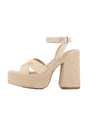 Sandalia de tacón plataforma beige con correas trenzadas tejidas, hebilla en el tobillo y detalles de cuerda texturizada en el tacón.