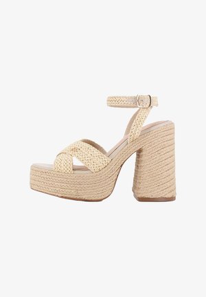 Sandalia de tacón plataforma beige con correas trenzadas tejidas, hebilla en el tobillo y detalles de cuerda texturizada en el tacón.