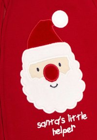 Tela roja con un rostro de Santa bordado. Barba y gorro blancos, con una nariz roja y ojos sonrientes. El texto dice "el pequeño ayudante de Santa".