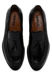 Mocassins en cuir noir avec détail en frange, texture lisse, accents cousus et un design légèrement pointu. Doublure en cuir marron.