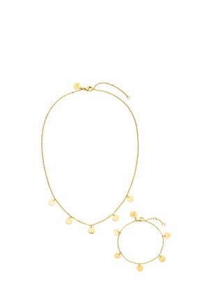 Zarte goldene Halskette und passendes Armband mit gleichmäßig verteilten kleinen runden goldenen Scheiben als Anhänger auf weißem Hintergrund.