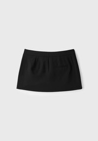 Mini-jupe noire avec une taille ajustée et une petite poche passepoilée à l'avant sur un fond clair uni.
