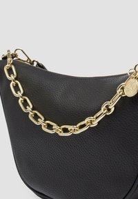Schwarze Lederhandtasche mit strukturiertem Oberflächen, ausgestattet mit einem goldenen Kettenriemen und einem Reißverschluss oben. Akzentuiert mit einem runden Logo-Anhänger.