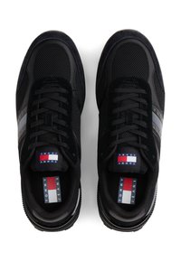 Schwarze Sneaker aus einer Kombination von Mesh- und Wildledermaterialien, mit einem kontrastierenden Streifen und Logodetail auf der Zunge. Profilsohle.