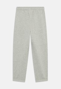 Pantalons de survêtement gris en tissu doux, avec une taille élastique, des jambes fuselées et des ourlets cousus, présentant une texture uniforme et lisse.