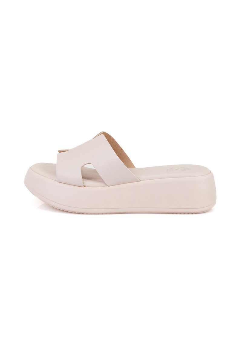 Sandales à plateforme blanches avec un design à lanières croisées, fabriquées à partir d'un matériau lisse. Elles sont dotées d'une semelle intérieure rembourrée et d'une semelle extérieure texturée pour une bonne adhérence.