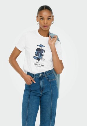 White t-shirt featuring a graphic illustration in blue, paired with high-waisted blue jeans. Model holds a light blue jacket over her shoulder.