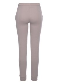 Lichtgrijze slanke broek gemaakt van rekbaar materiaal, met een gladde textuur en een geribde tailleband, die aan de enkels taps toeloopt.
