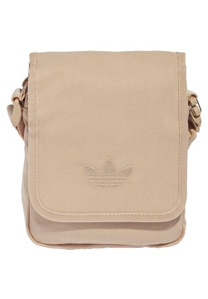 Sac bandoulière beige avec fermeture à rabat, arborant un logo Adidas Trefoil cousu et une sangle latérale ajustable.