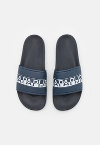 Un paio di sandali scivolati blu scuro con cinturini brandizzati bianchi e neri, letti per i piedi texturizzati, mostrati dall'alto su uno sfondo bianco.