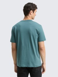 Teal katoenen t-shirt met korte mouwen, ronde hals en een relaxed fit; weergegeven van achteren met een gladde textuur en eenvoudig ontwerp.