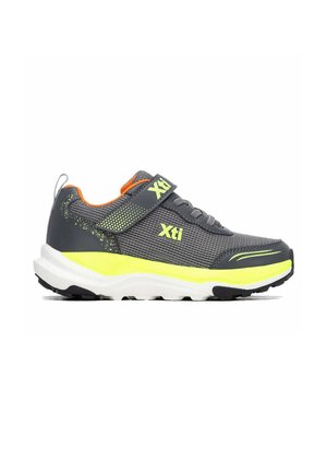 Zapatilla deportiva gris y amarilla con parte superior de malla, cierre de velcro y suela acolchada, con logotipo de la marca en el lateral y en la tira.