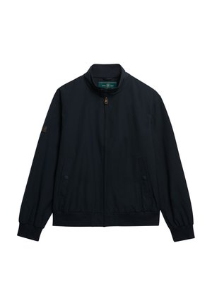 Chaqueta azul marino con cremallera y cuello alto, puños elásticos, dos bolsillos laterales y parche de logotipo en la manga izquierda. Acabado de tela suave.