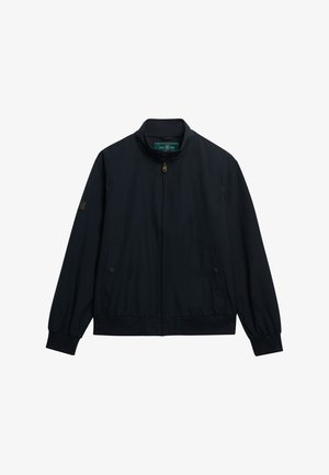 Chaqueta azul marino con cremallera y cuello alto, puños elásticos, dos bolsillos laterales y parche de logotipo en la manga izquierda. Acabado de tela suave.