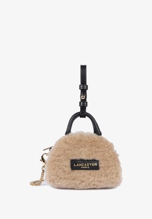 Borsa a tracolla in ecopelliccia beige con manico e tracolla in pelle nera. Presenta una patch con logo dorato e dettagli in hardware dorato. Design arrotondato.