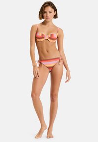 Stripet bikini sæt med polstrede underwire-top og justerbare bånd-sidede bund i nuancer af pink, orange og brun. Glat stofstruktur.