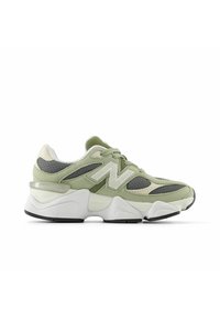 Hellgrüne Sneaker mit strukturiertem Wildleder und Mesh, ausgestattet mit einem auffälligen weißen Logo, einer klobigen Mittelsohle und einer schwarzen Gummiaußensohle.