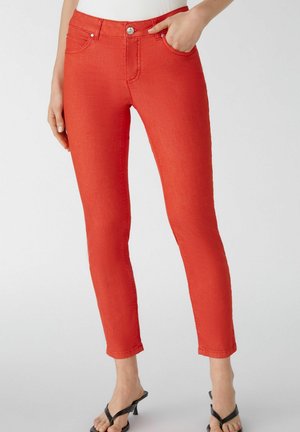 Rode denim skinny jeans met een middelhoge taille, voorzakken en subtiele stikdetail. Draagt met zwarte sandaaltjes met bandjes.