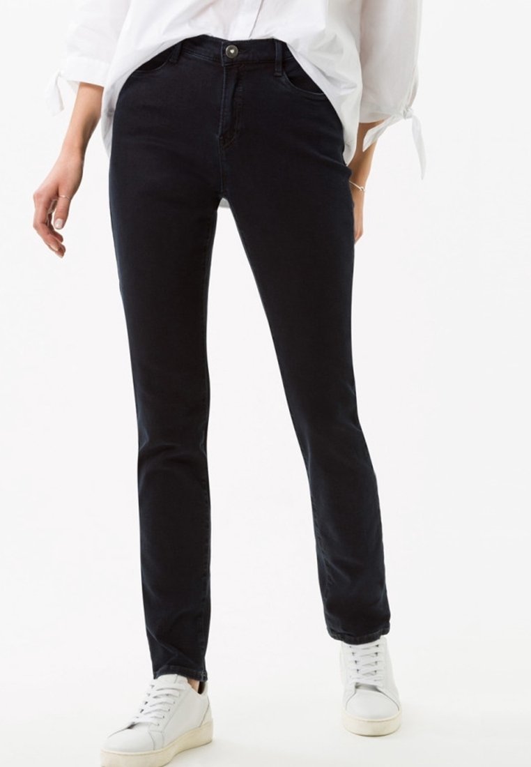 Mustat farkut slim fit -leikkauksella ja viiden taskun designilla, joissa on nappisuljenta ja hienovarainen venyvyys mukavuutta varten. Yhdistetty valkoisiin tennareihin.