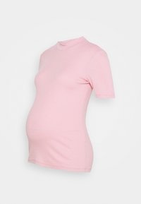 Krátký rukáv těhotenské tričko v jemně růžové barvě, vyrobené z ribkované tkaniny s přiléhavým střihem. Má vysoký výstřih a zakřivený lem.