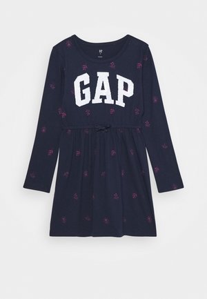 Robe bleu marine à manches longues avec de petits imprimés floraux roses et "GAP" imprimé en grandes lettres blanches sur la poitrine.