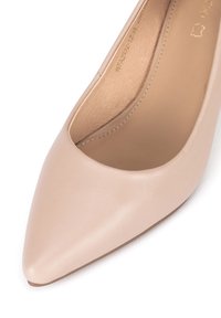 Zapato de salón de cuero beige con tacón alto, punta puntiaguda, textura lisa y diseño minimalista. En el interior tiene un forro suave y costuras visibles.