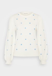 Witte lange mouwen trui met poffende mouwen en kleine blauwe geborduurde bloemen verspreid over de voorkant en mouwen.