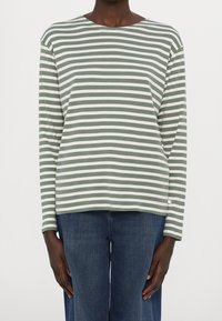 Dlouhý rukáv top v jemně zelených a bílých pruzích, vyrobený z měkké tkaniny, s kulatým výstřihem a uvolněným střihem. Neformální design.