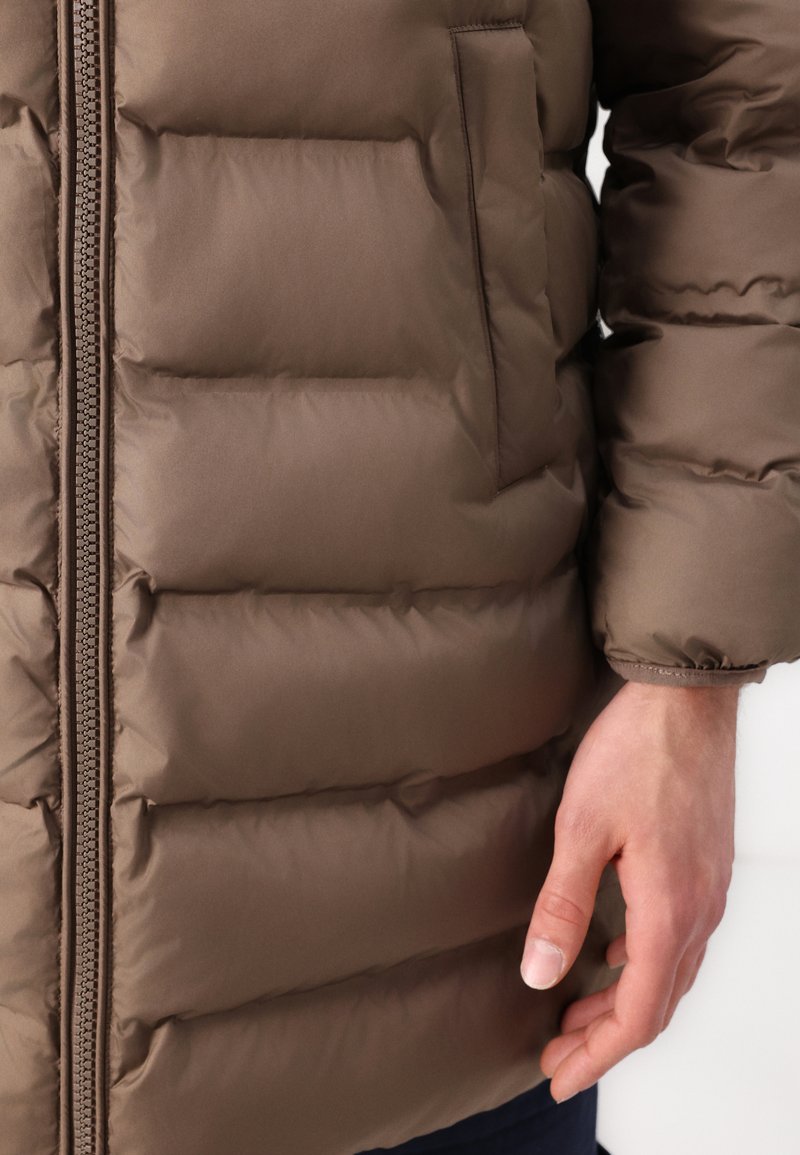 Braune gepolsterte Jacke mit Reißverschluss, versehen mit gestepptem Design und einer Seitentasche. Glattes, glänzendes Material mit elastischen Bündchen.