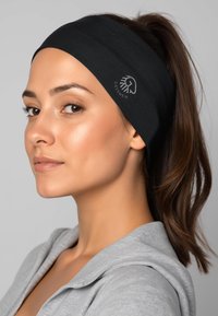 Bandeau en tissu noir à texture lisse, avec un logo sur le côté. Le design entoure la tête en couvrant partiellement les cheveux.