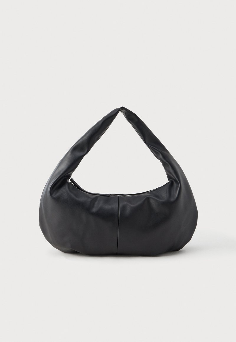 Musta pehmeä nahkainen kuun muotoinen käsilaukku, jossa on paksu, pehmustettu kahva ja yläosassa vetoketjulla suljettava suljenta.