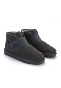 Botines de ante gris con un suave forro de piel y una amplia correa elástica. La suela es plana y texturizada para mayor agarre. Diseño simple con detalles mínimos.
