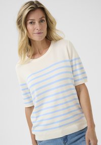 Pull en tricot crème avec des rayures horizontales bleu et bleu clair, manches courtes et col rond. Matière douce, coupe décontractée.